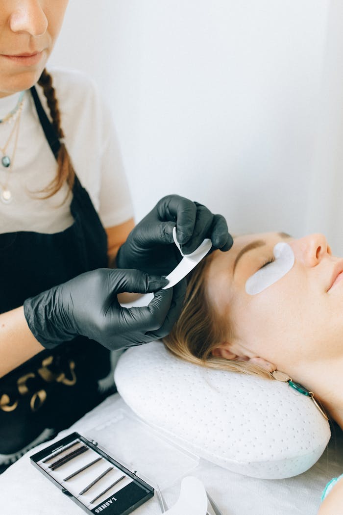 ours-journey Professional applying eyelash extensions on a young woman in a beauty salon.