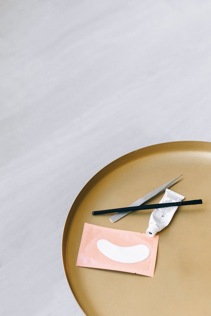 about-img Minimalist flat lay of skincare tools and eye mask on round golden tray, ideal for beauty and wellness concepts.